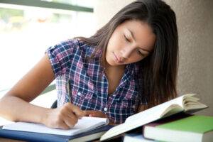 female student concentrating on reading and writing