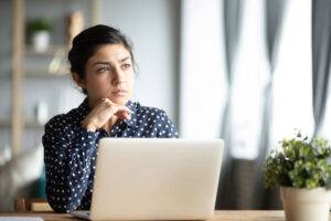 thoughtful woman at her laptop