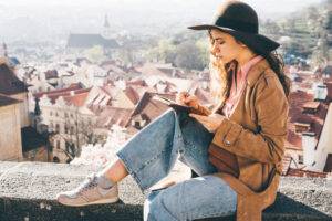 woman in brown hat writing