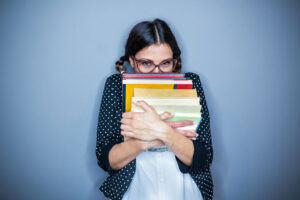 girl holding stack of books