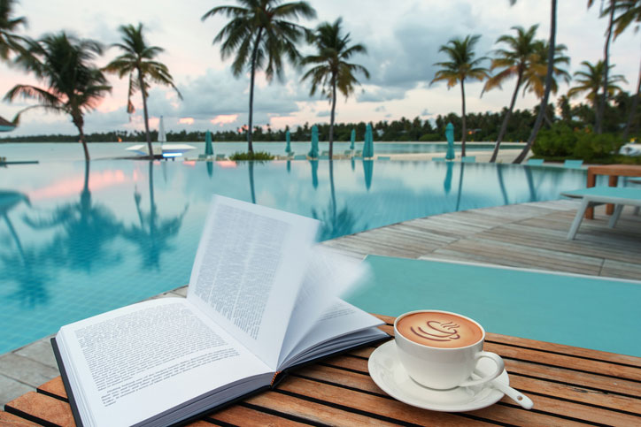 open book and coffee poolside