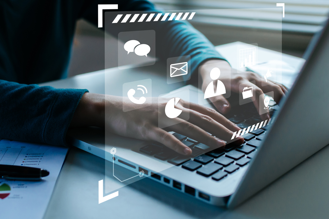 woman's hands working on laptop computer with virtual social media icon diagram